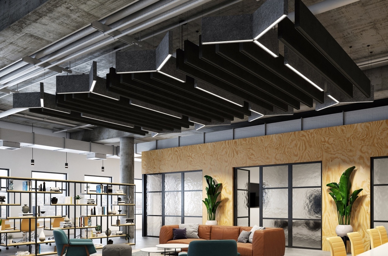 Open lounge space, with couches, plants and black ceiling lighting