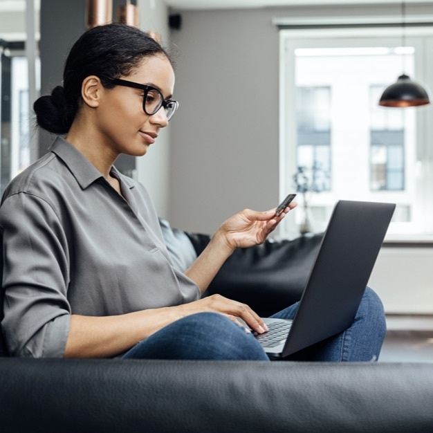 Woman looking at credit card and doing some online shopping on her laptop