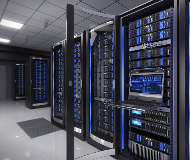 Close up of data center with a laptop attached to data center on the right hand side with more data center systems seen in the distance on the left hand side