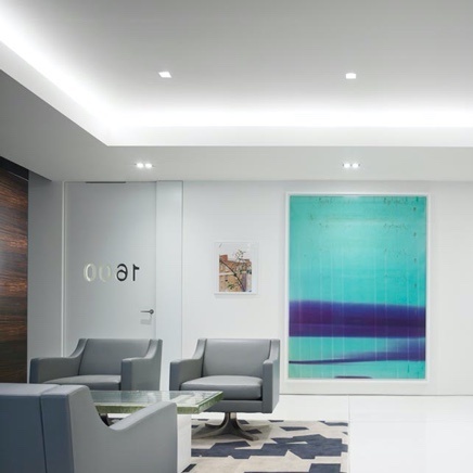 Well lit, lobby with grey couches and wall paintings