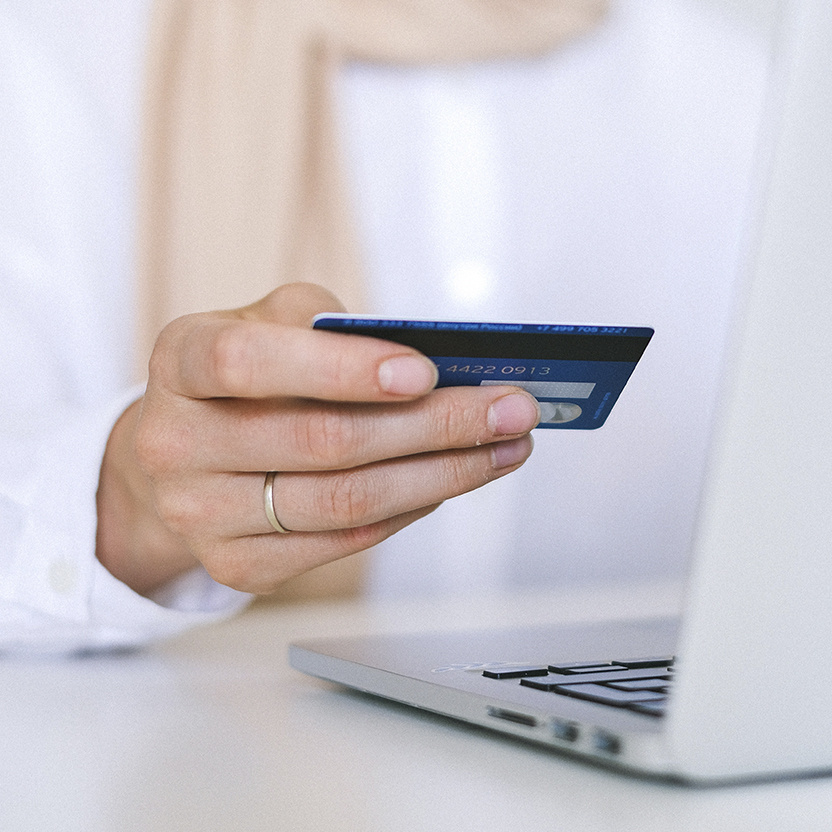 Woman entering credit card information online while she is on her laptop