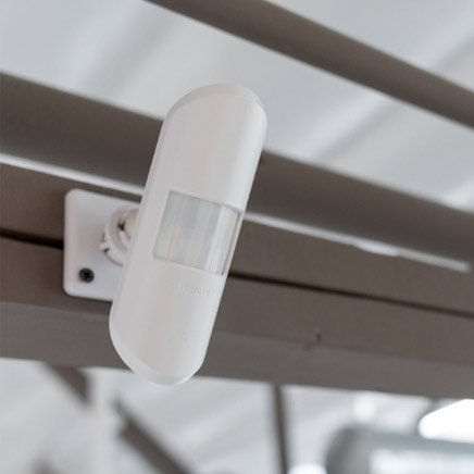 Wireless lighting sensor mounted on metal beam