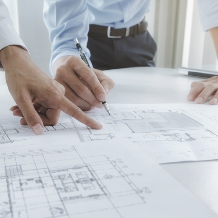 People pointing to engineering designs