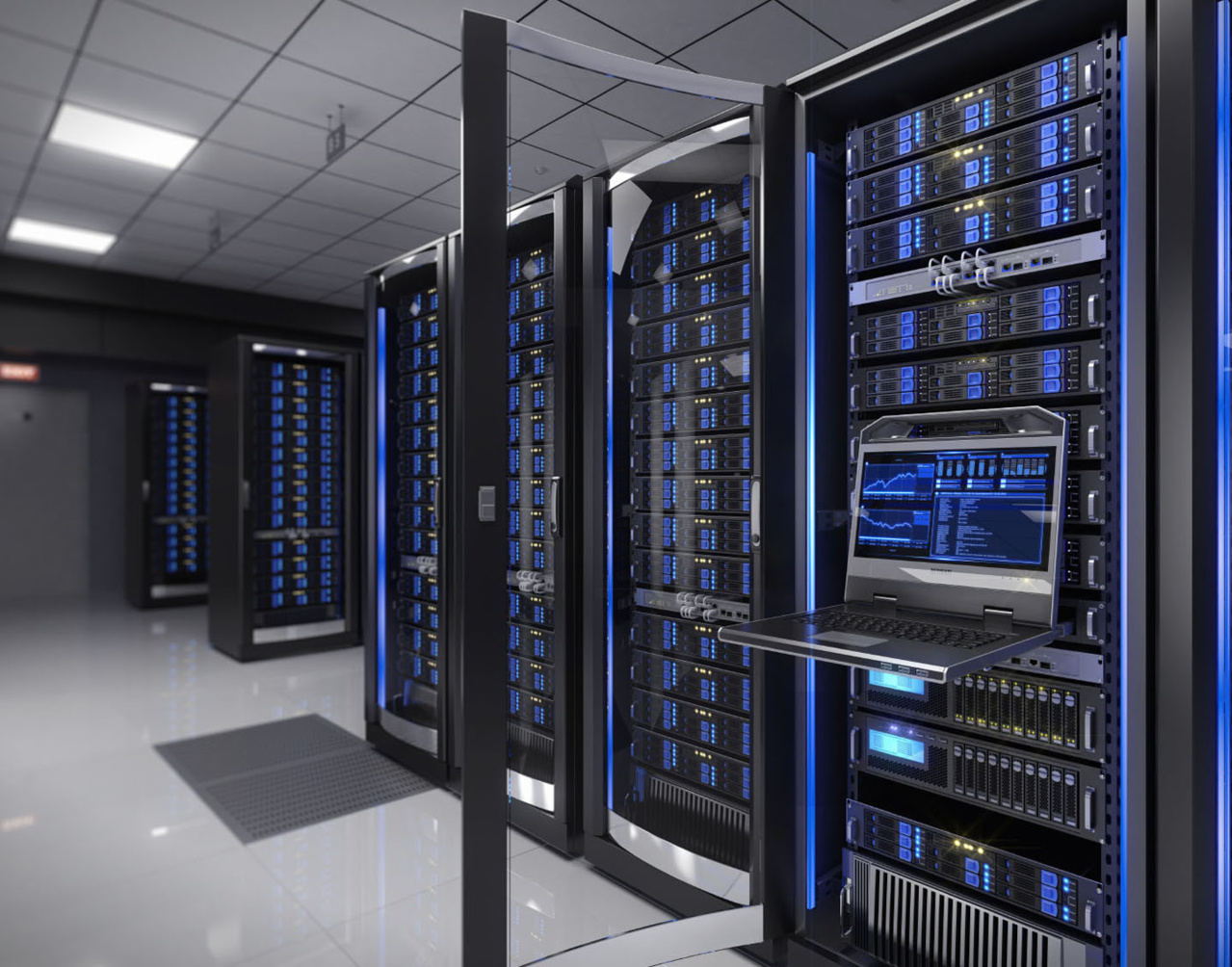 Close up of data center with a laptop attached to data center on the right hand side with more data center systems seen in the distance on the left hand side