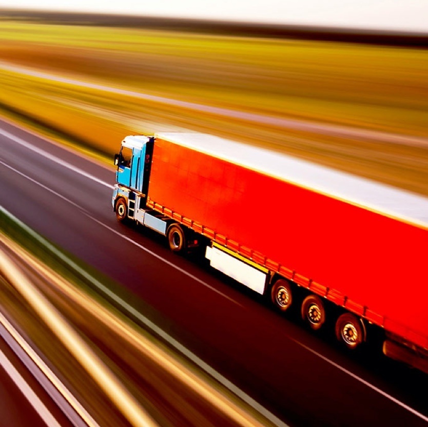 Red freight trunk driving on a highway 