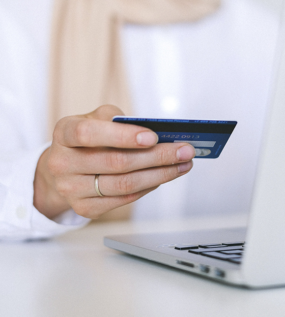 Woman entering credit card information online while she is on her laptop